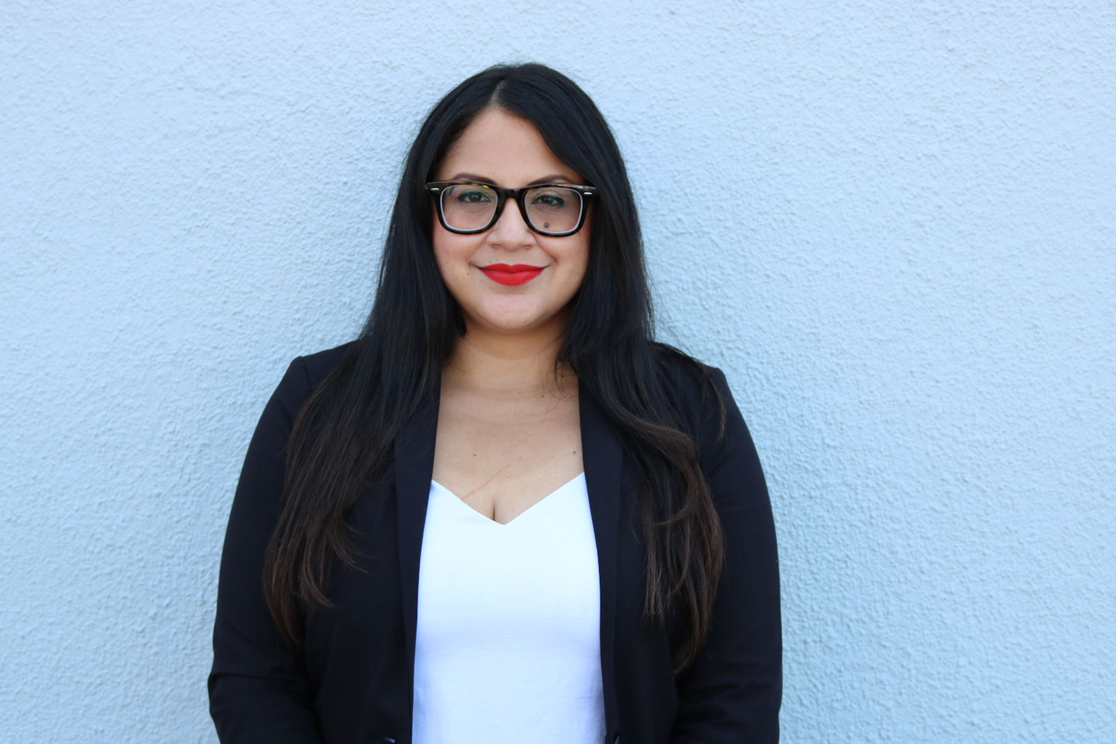 A woman wearing glasses and a black jacket.