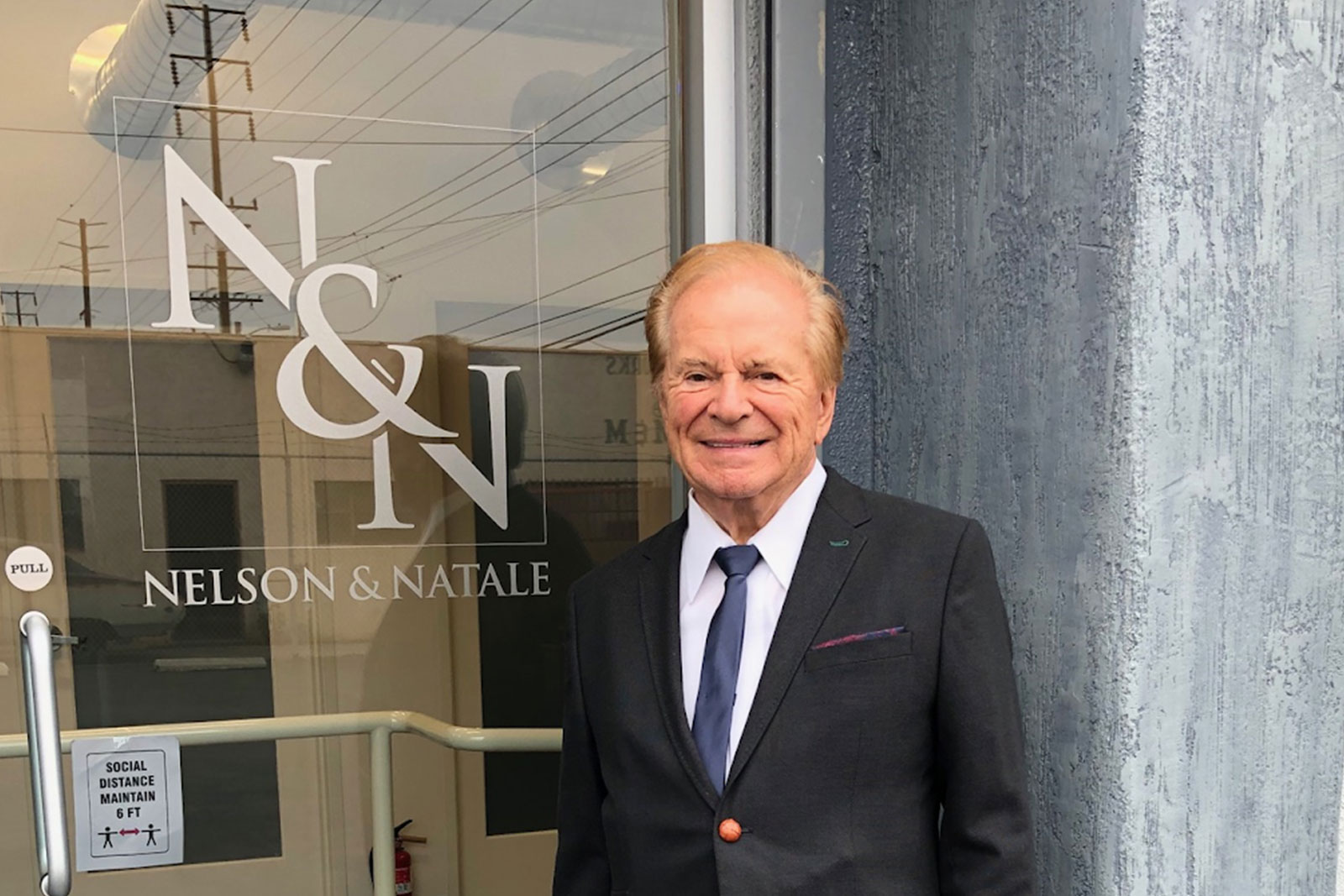 A man in suit and tie standing outside of a building.