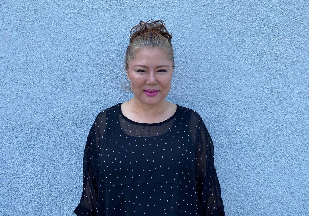 A woman standing in front of a wall.