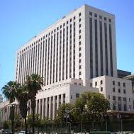 A large white building with palm trees in front of it.